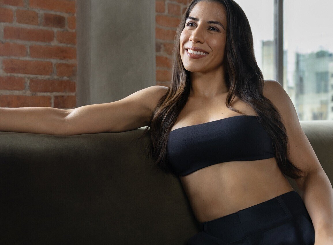 Imagen de campaña MIA Femtech: mujer sentada con un top negro.